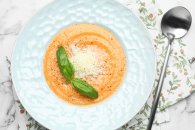 Photo of Delicious sweet potato soup served on white marble table, flat lay