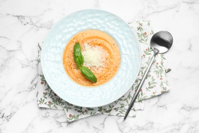 Photo of Delicious sweet potato soup served on white marble table, flat lay