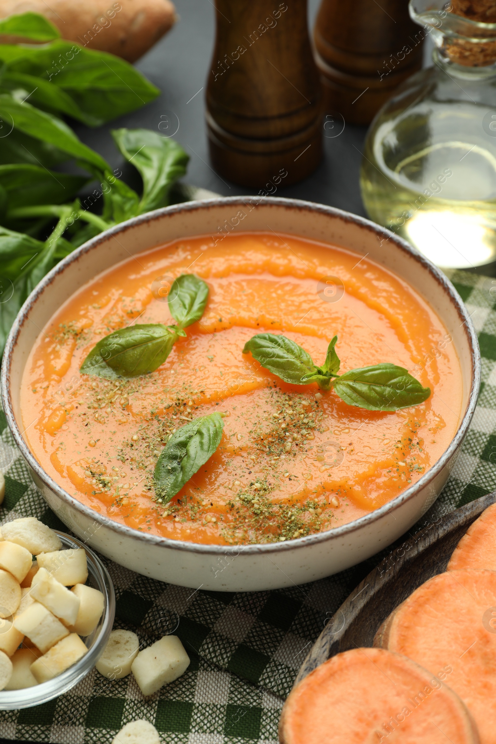 Delicious sweet potato soup in bowl served on grey table Photo of Delicious sweet potato soup in bowl served on grey table