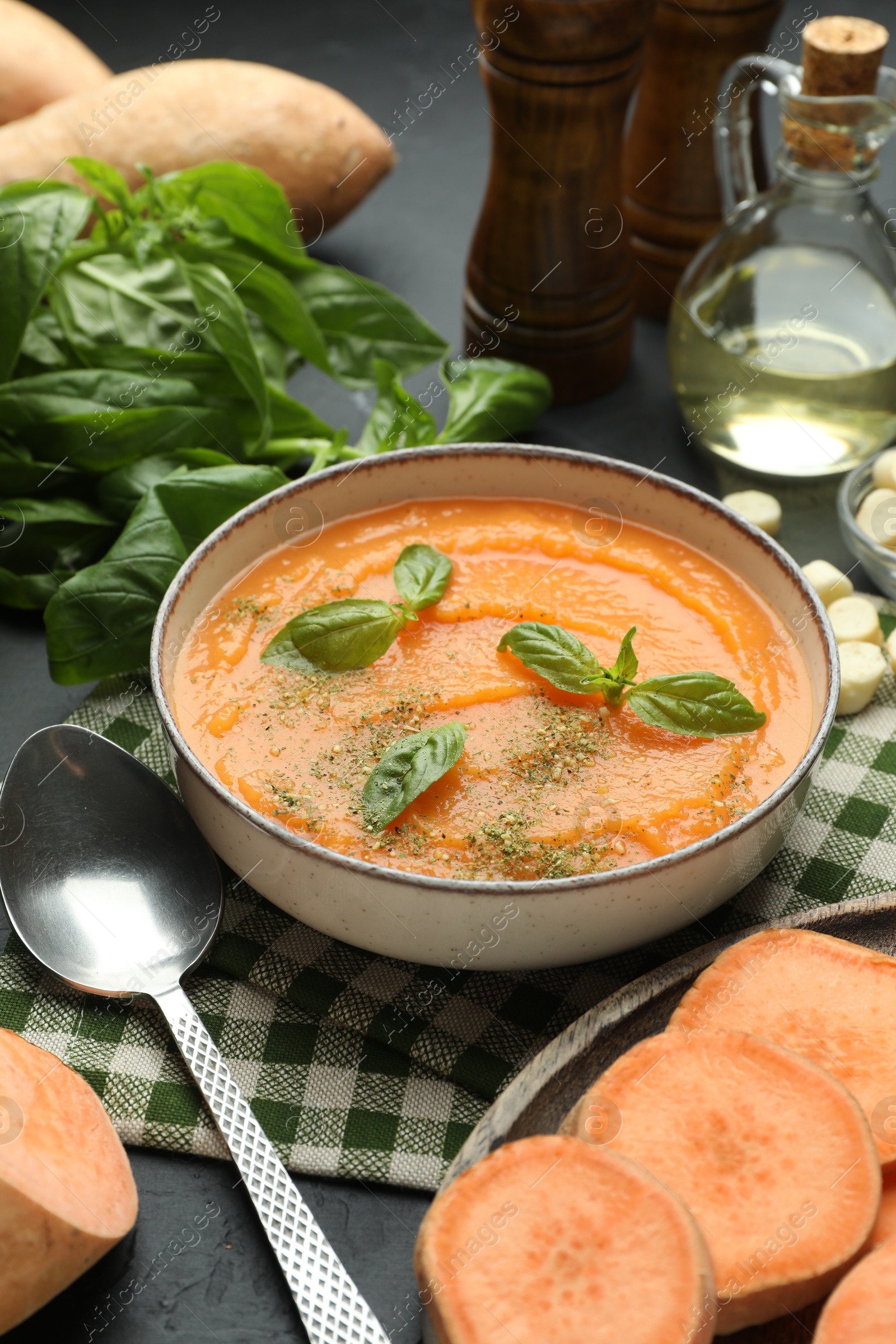 Photo of Delicious sweet potato soup in bowl served on grey table