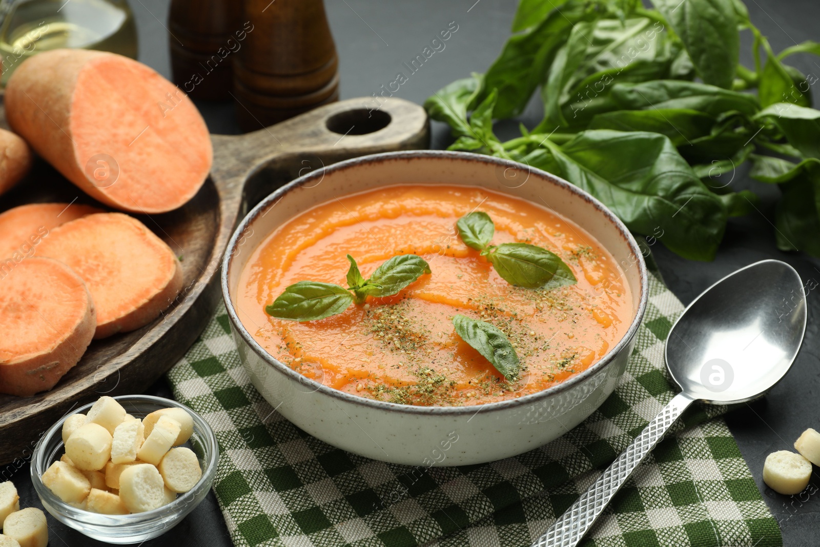 Delicious sweet potato soup in bowl served on grey table, closeup Photo of Delicious sweet potato soup in bowl served on grey table, closeup