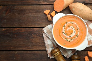 Photo of Delicious sweet potato soup with microgreens and fresh vegetables on wooden table, flat lay. Space for text