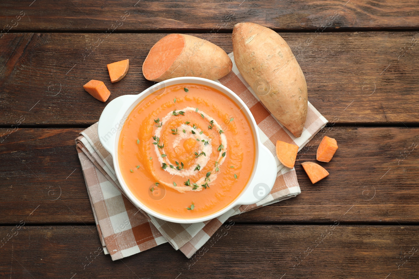 Photo of Delicious sweet potato soup with microgreens and fresh vegetables on wooden table, flat lay