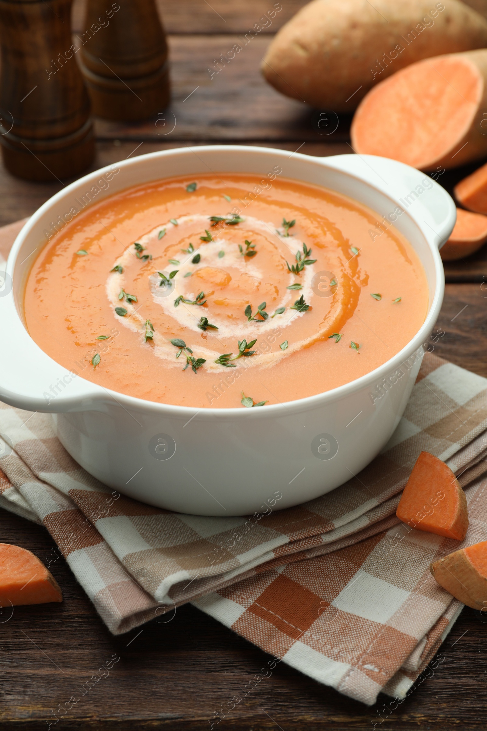 Delicious sweet potato soup with microgreens and fresh vegetables on wooden table, closeup Photo of Delicious sweet potato soup with microgreens and fresh vegetables on wooden table, closeup