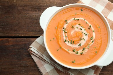 Photo of Delicious sweet potato soup with microgreens on wooden table, top view. Space for text