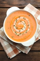 Photo of Delicious sweet potato soup with microgreens on wooden table, top view