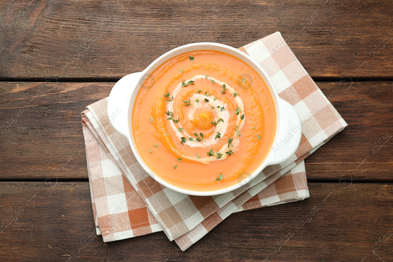 Photo of Delicious sweet potato soup with microgreens on wooden table, top view