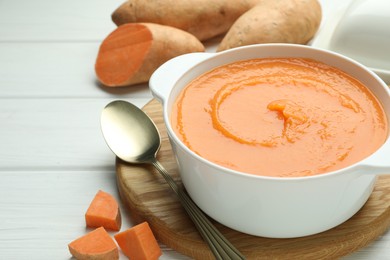 Photo of Delicious sweet potato soup served on white wooden table, closeup