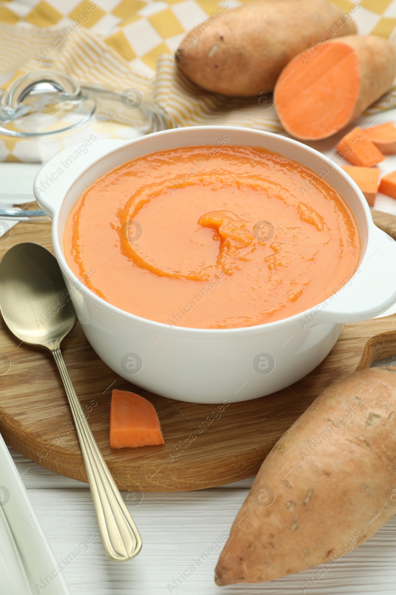 Photo of Delicious sweet potato soup served on white wooden table