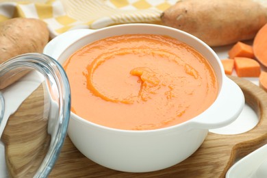 Photo of Delicious sweet potato soup on white table, closeup