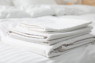 Stack of clean linens on bed indoors, closeup