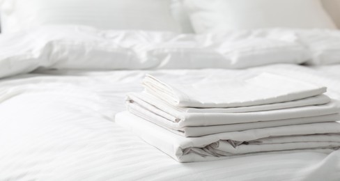 Photo of Bed with clean linens and pillows indoors, closeup