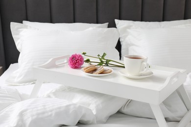 Photo of Breakfast tray on bed with beautiful linens indoors