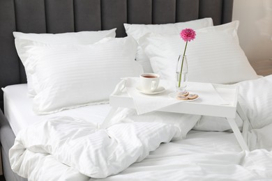 Photo of Breakfast tray on bed with beautiful linens indoors