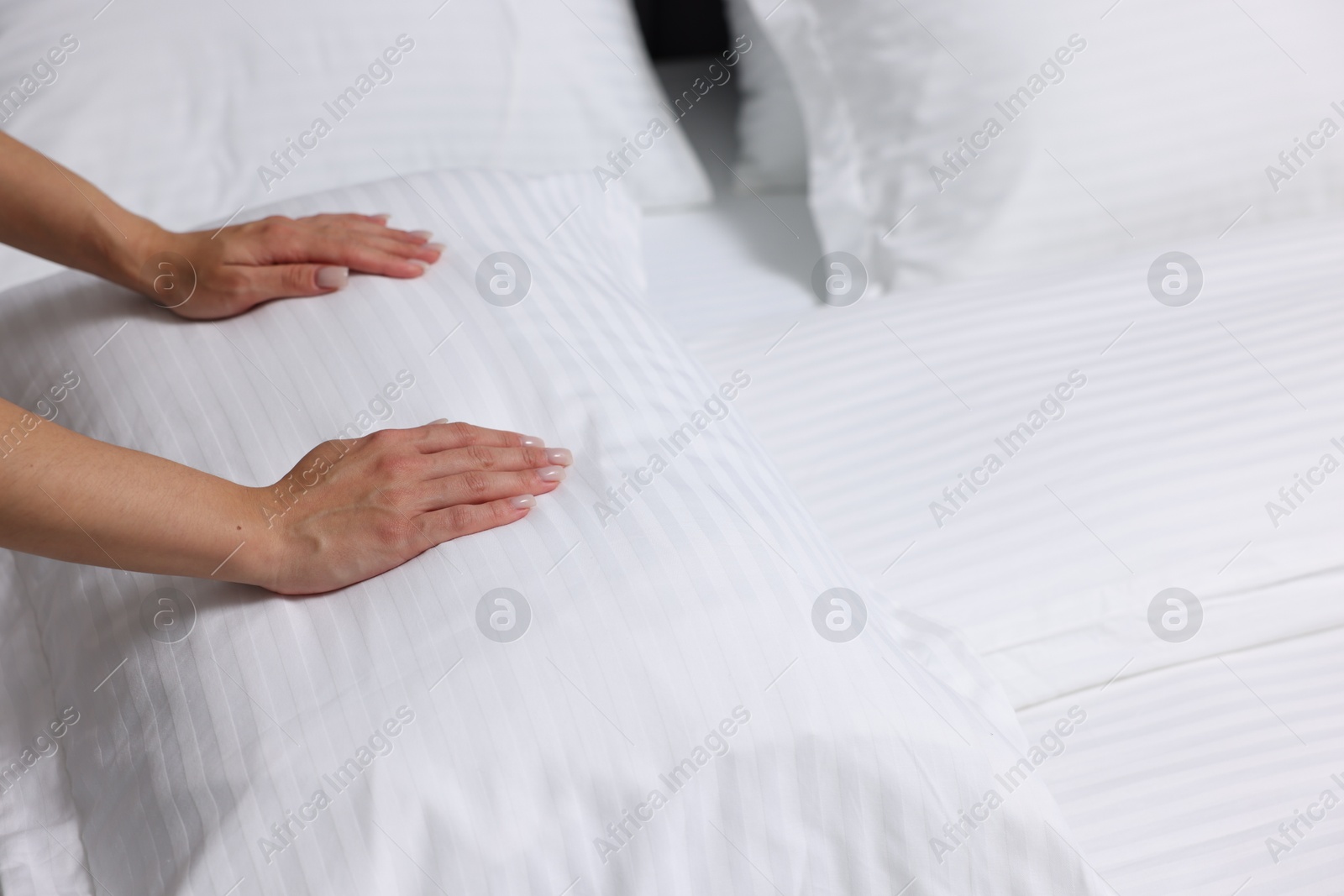 Photo of Woman changing clean bed linens at home, closeup