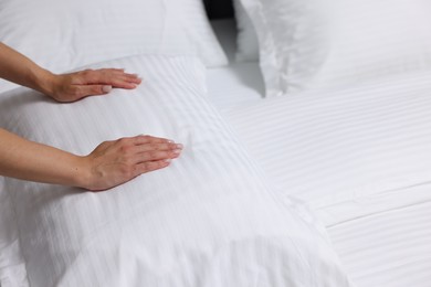 Photo of Woman changing clean bed linens at home, closeup