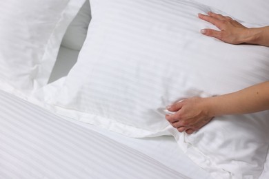 Photo of Woman changing clean bed linens at home, closeup