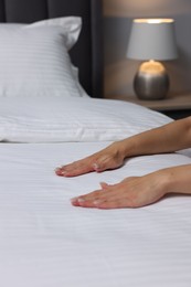 Woman changing clean bed linens at home, closeup