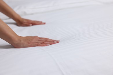 Woman changing clean bed linens at home, closeup