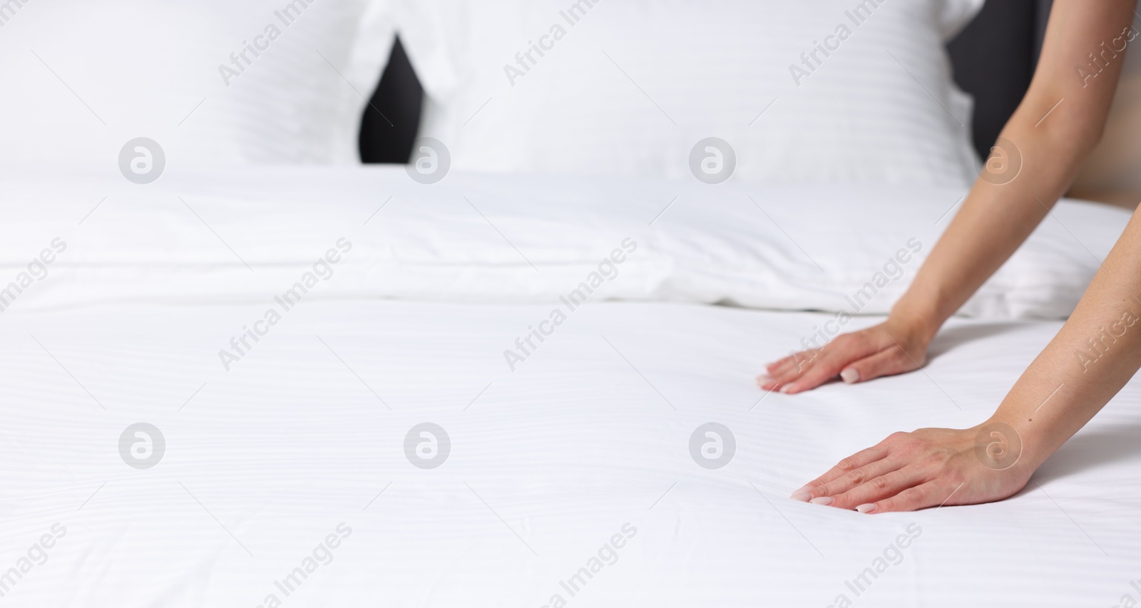 Photo of Woman changing clean bed linens at home, closeup