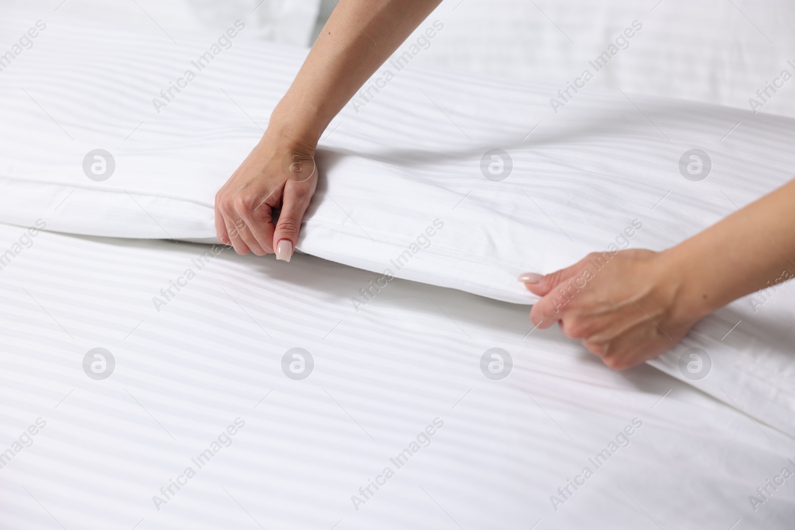 Photo of Woman changing clean bed linens at home, closeup