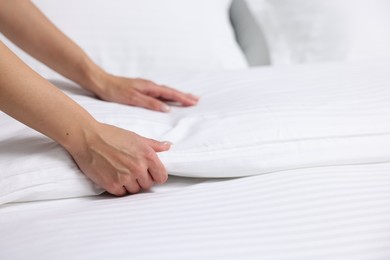 Woman changing clean bed linens at home, closeup