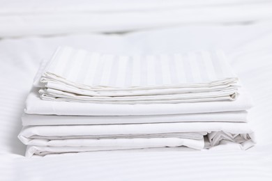 Photo of Stack of clean linens on bed indoors, closeup