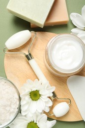 Photo of Flat lay composition with face roller and gua sha tool on green background