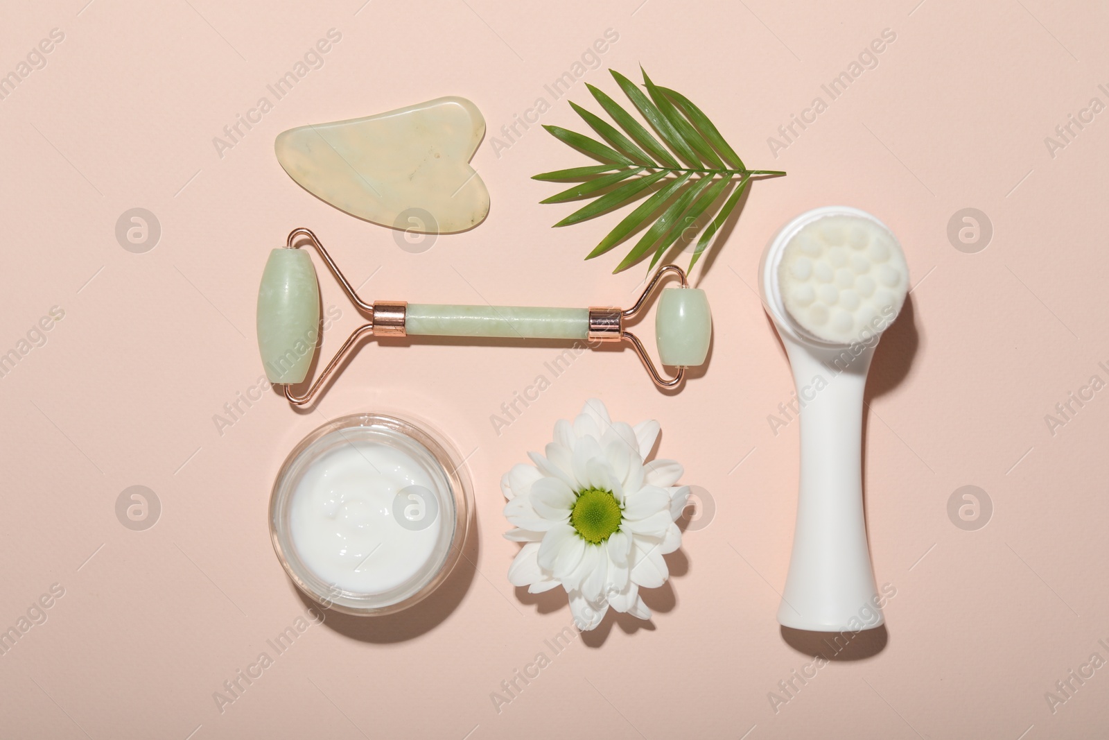 Photo of Flat lay composition with face roller and gua sha tool on beige background