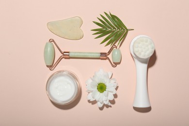 Photo of Flat lay composition with face roller and gua sha tool on beige background