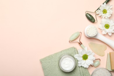 Photo of Flat lay composition with face rollers and gua sha tool on beige background, space for text