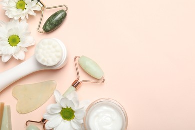 Photo of Flat lay composition with face rollers and gua sha tool on beige background, space for text