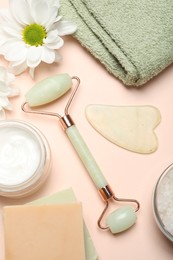 Photo of Flat lay composition with face roller and gua sha tool on beige background