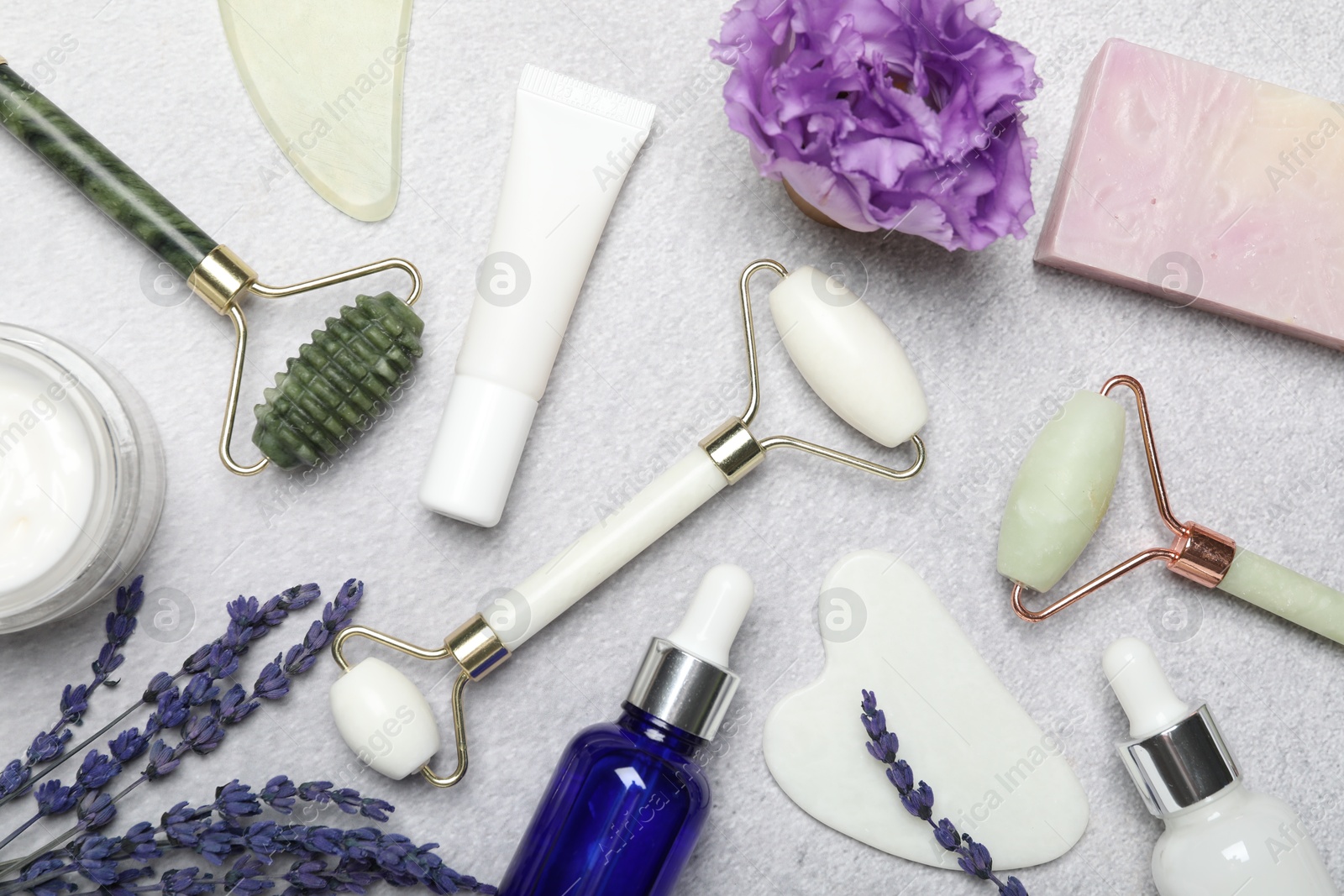 Photo of Flat lay composition with face rollers and gua sha tools on gray background