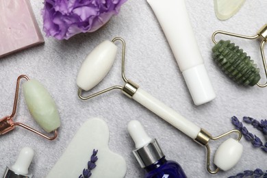 Flat lay composition with face rollers and gua sha tool on gray background