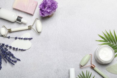 Photo of Flat lay composition with face rollers and gua sha tool on gray background, space for text