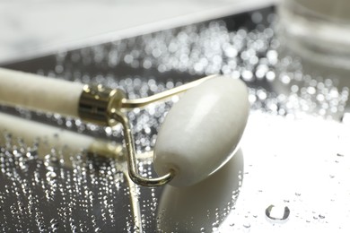 Face roller on mirror with water drops, closeup