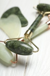 Face rollers on white wooden background, closeup