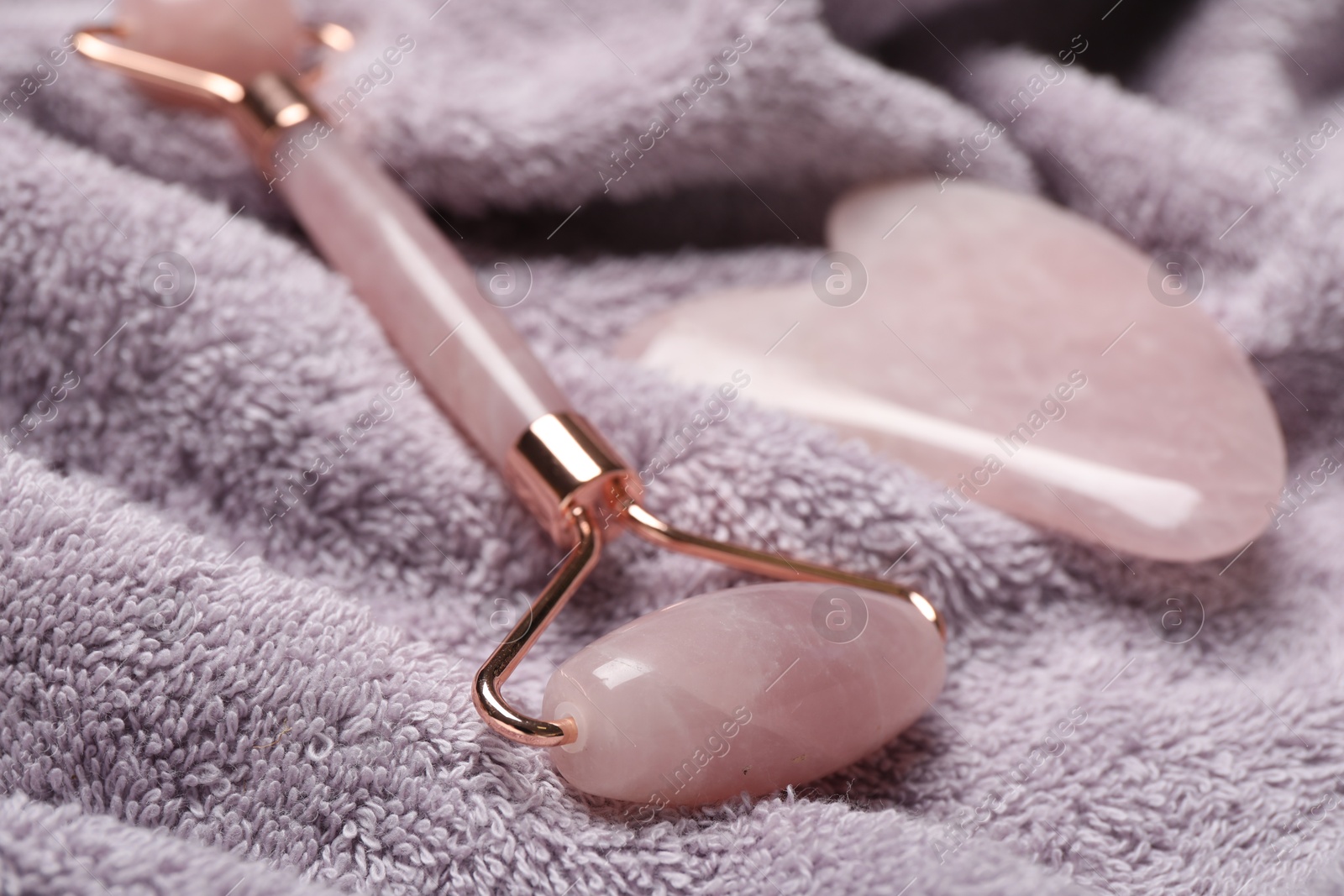 Photo of Face roller and gua sha tool on towel, closeup