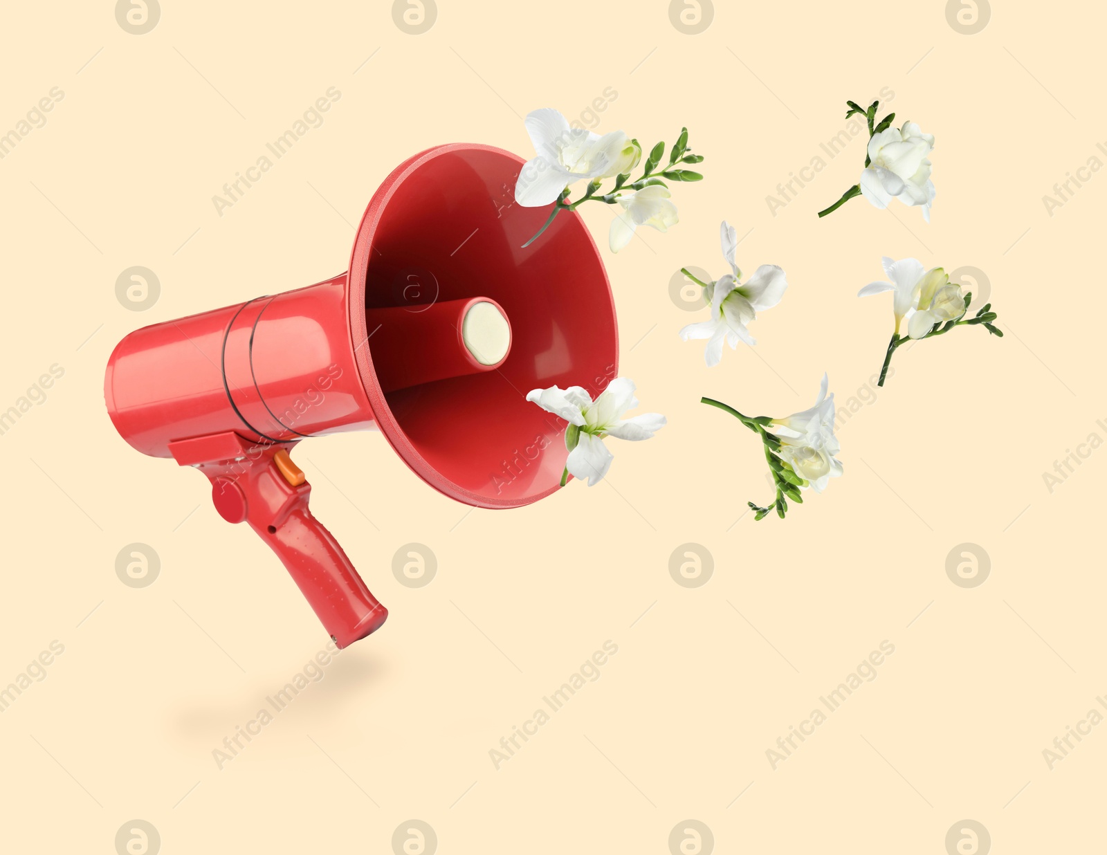 Image of White freesia flowers flying out of red loudspeaker on beige background