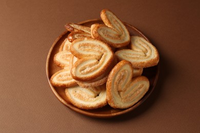 Photo of Tasty french palmier cookies on brown background, closeup