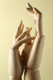 Photo of Wooden mannequin hands on beige background, closeup