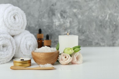 Photo of Spa composition with cosmetic products and towels on white table. Space for text