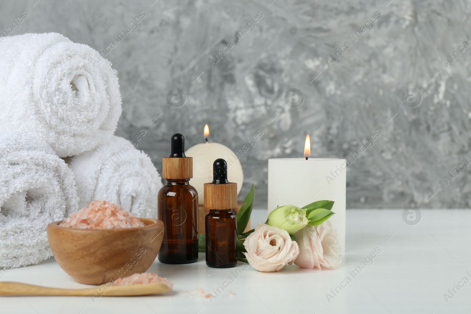 Photo of Spa composition with cosmetic products and towels on white table