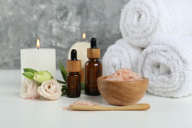 Photo of Spa composition with cosmetic products and towels on white table