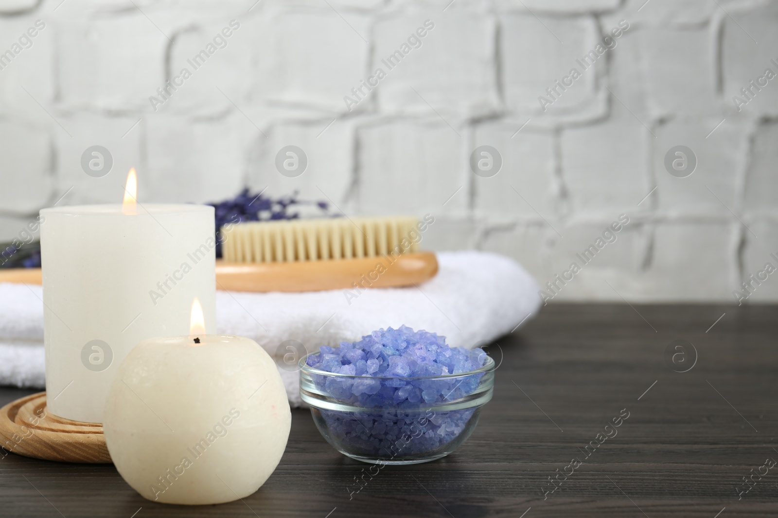 Photo of Spa treatment. Composition with burning candles and towel on wooden table