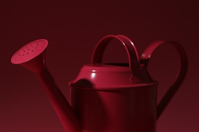 Photo of Metal watering can on bright pink background, closeup