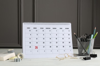 Photo of Timetable. Monthly planner, stationery and glasses on white table