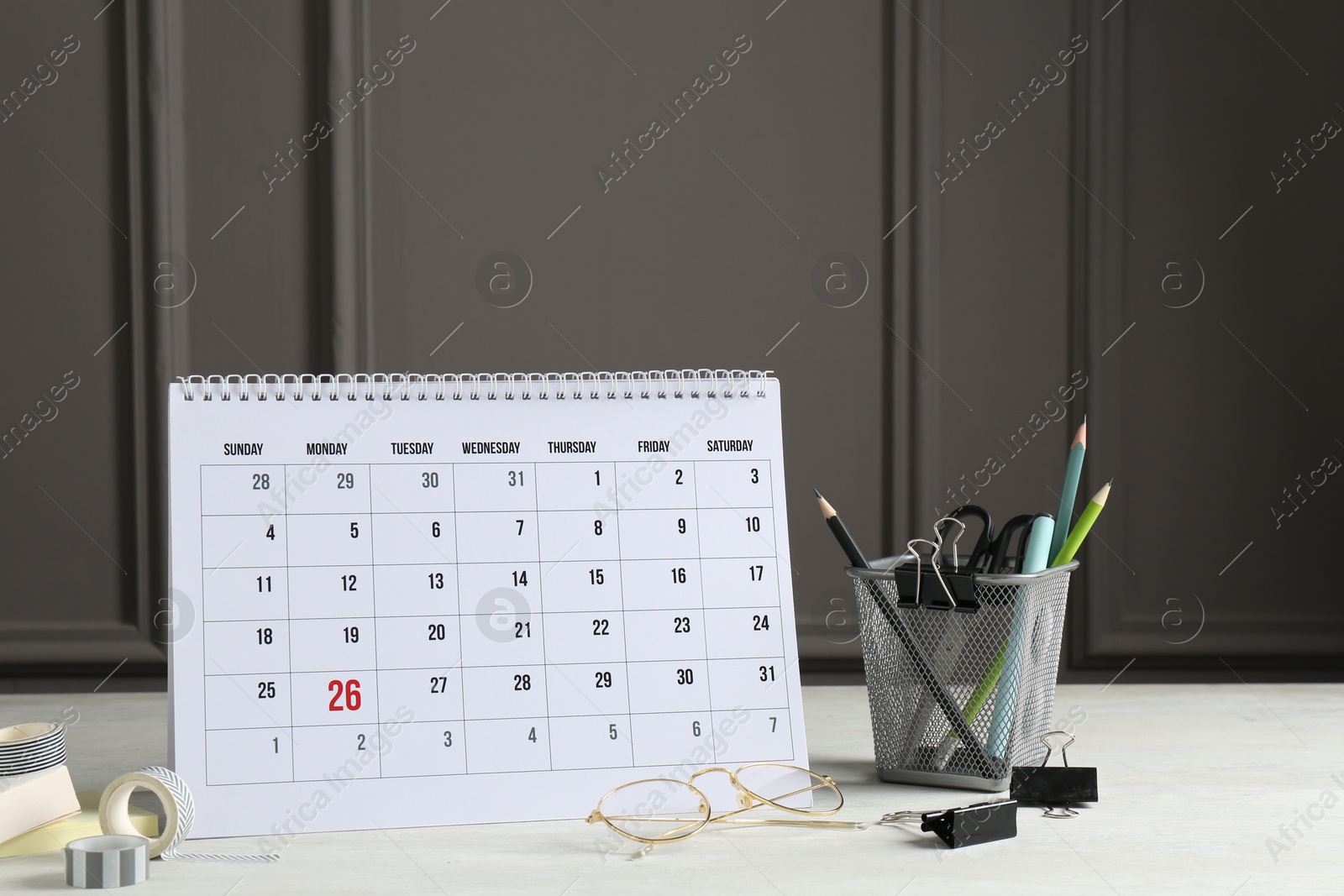 Photo of Timetable. Monthly planner, stationery and glasses on white table