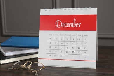 Photo of Timetable. Monthly planner, notebooks and glasses on wooden table